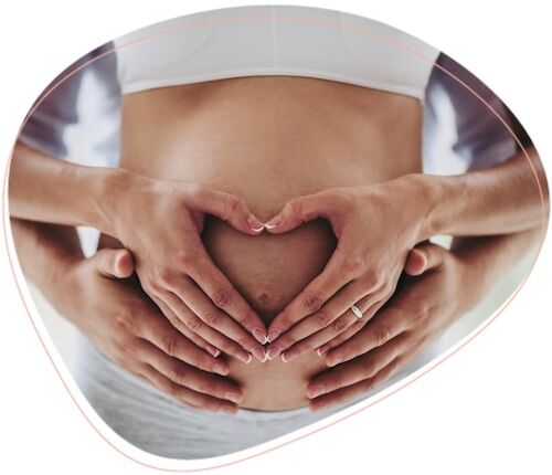 Schwangere Frau mit Händen auf dem Babybauch