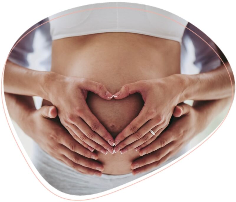 babybauch mit händen in herzform