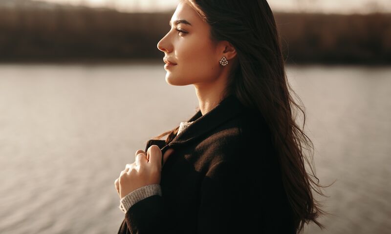 Junge Frau blickt nachdenklich zur Seite – symbolisiert Unsicherheit bei PCOS-Symptomen und Hormonproblemen